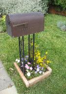 mailbox in area of flowers bounded by bricks